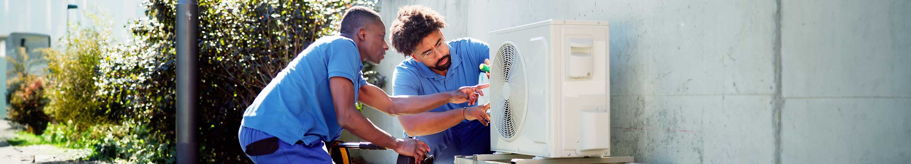 two contractors working on HVAC unit